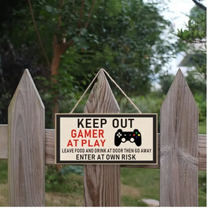 Gamer At Play Wood Sign hanging on a fence